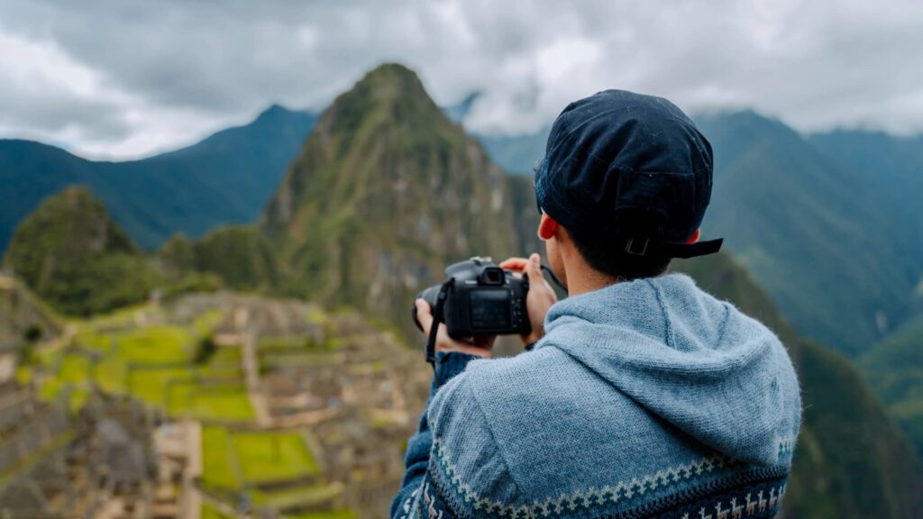 Traveler taking photos at Machu Picchu viewpoint in Peru